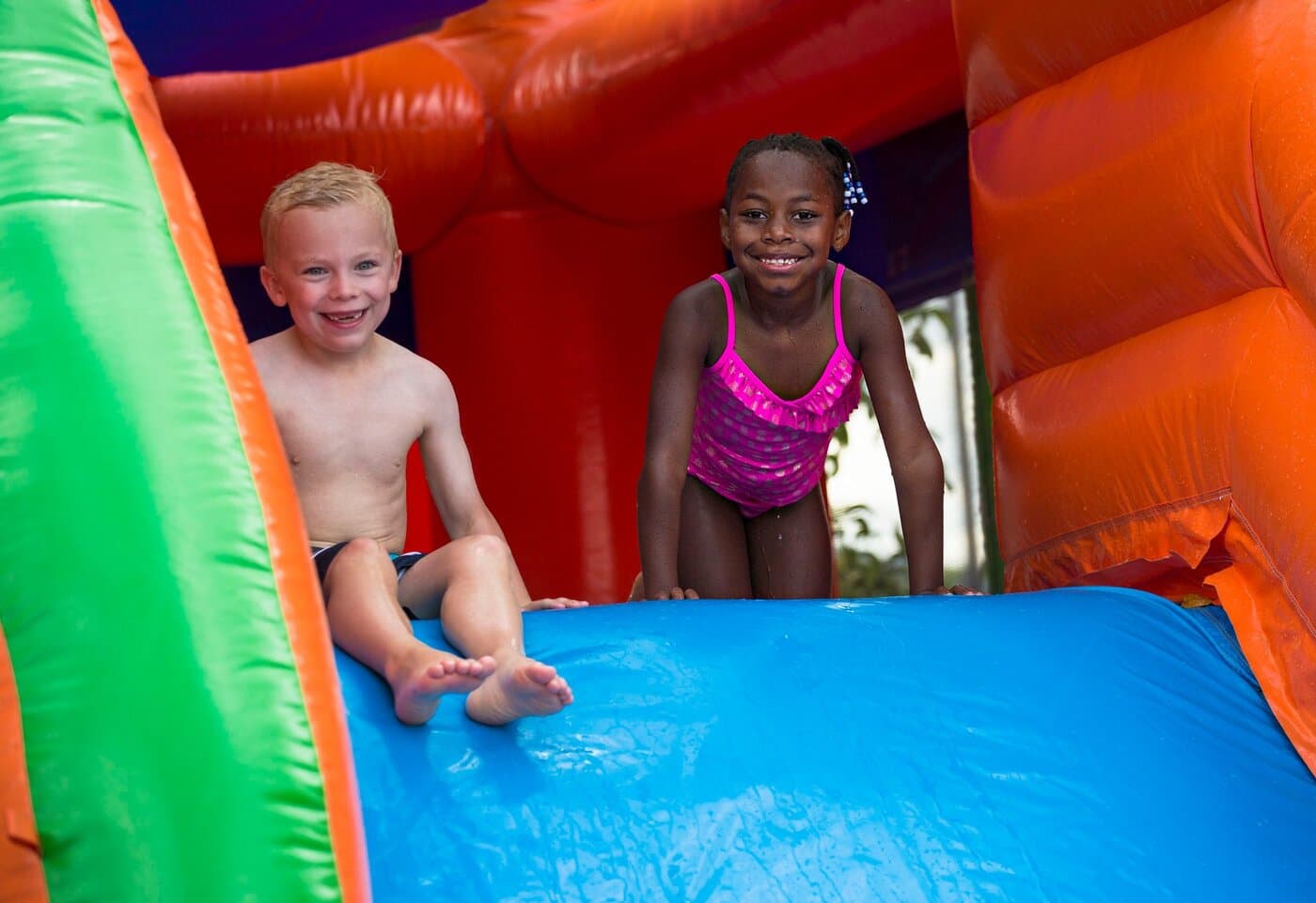 Kids laughing on an inflatable water slide