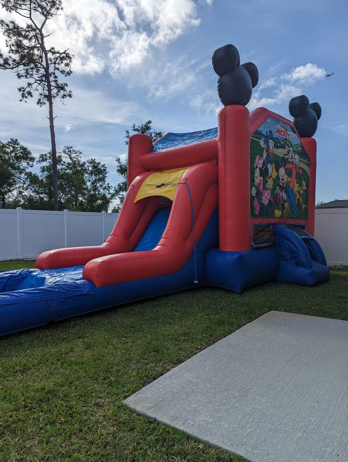 Combo bounce house with water slide set up in a residential backyard in Johnson County