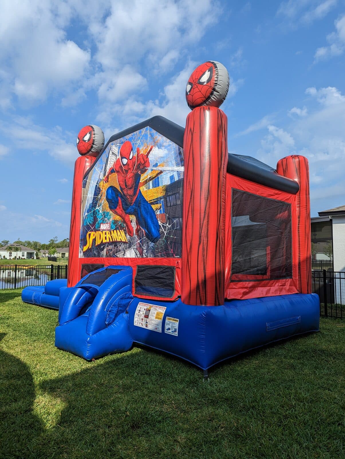 Spider-Man combo bounce house set up in a residential backyard