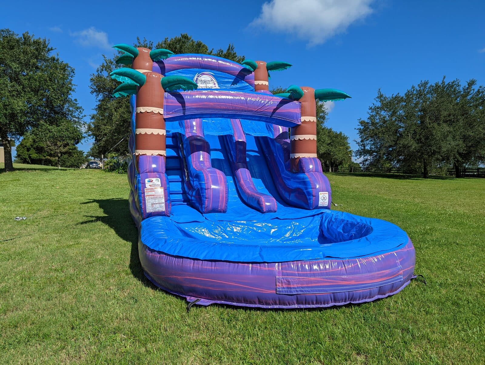 Inflatable water slide with splash pool set up in a Johnson County backyard